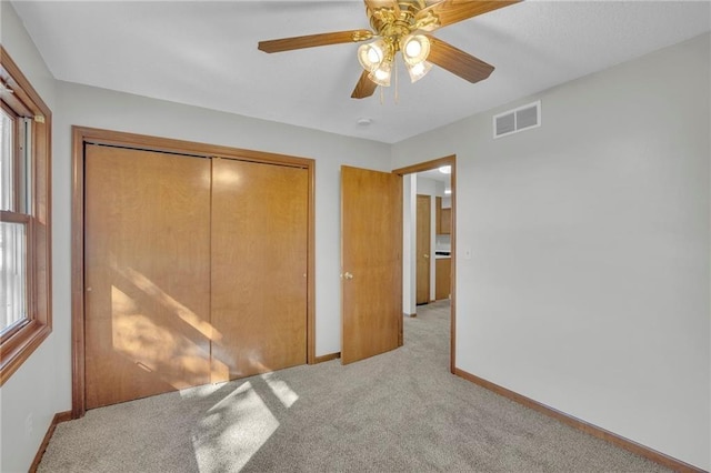 unfurnished bedroom featuring a closet, carpet, visible vents, and baseboards