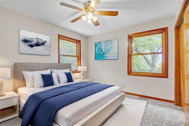 bedroom with a ceiling fan, visible vents, baseboards, and a textured ceiling