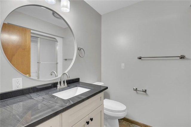 bathroom featuring vanity, toilet, and baseboards