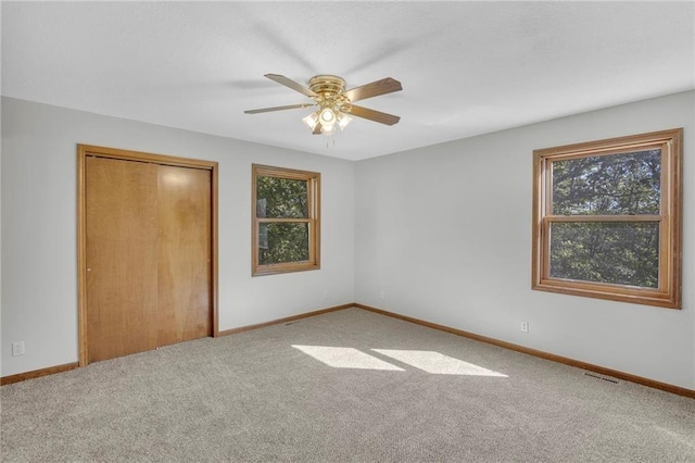 unfurnished bedroom with visible vents, baseboards, a ceiling fan, carpet floors, and a closet