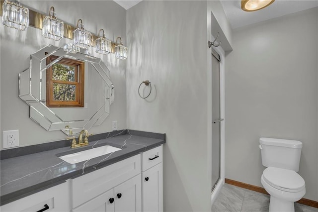 bathroom with toilet, a shower with shower door, baseboards, and vanity