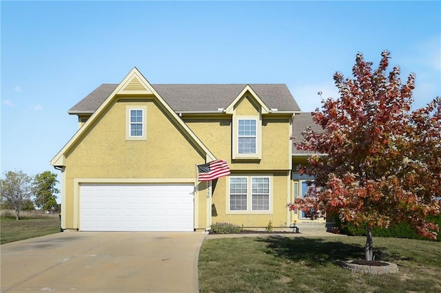 traditional-style house featuring driveway, a shingled roof, a front yard, and stucco siding