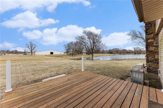 wooden deck featuring a water view and a lawn