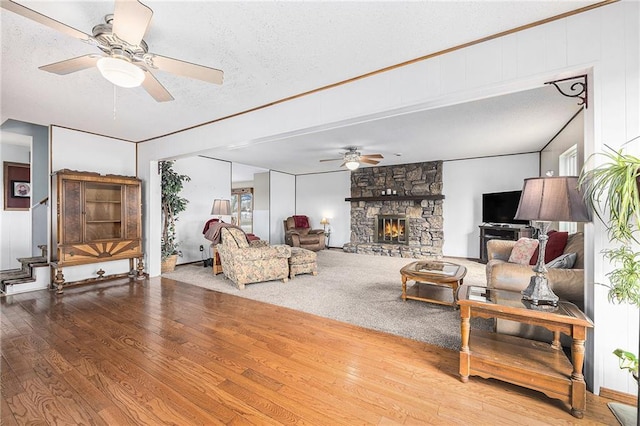 living area with a textured ceiling, ceiling fan, and hardwood / wood-style floors