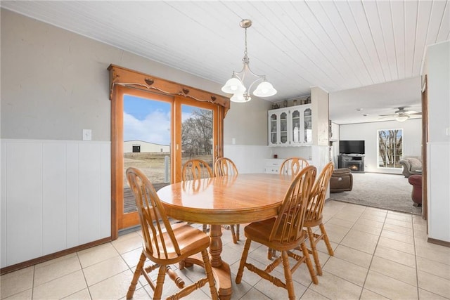 dining room with wooden ceiling, ceiling fan with notable chandelier, wainscoting, and light tile patterned flooring