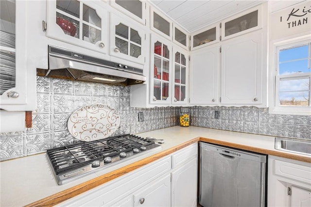 kitchen featuring stainless steel appliances, tasteful backsplash, light countertops, white cabinetry, and under cabinet range hood