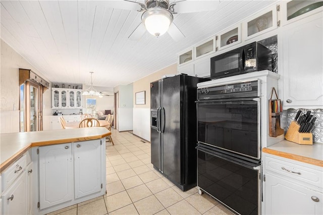 kitchen with glass insert cabinets, light countertops, white cabinetry, and black appliances