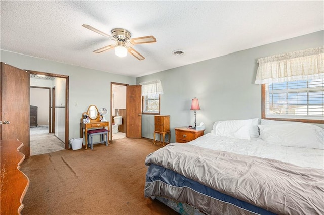 bedroom with a textured ceiling, carpet floors, visible vents, and a ceiling fan