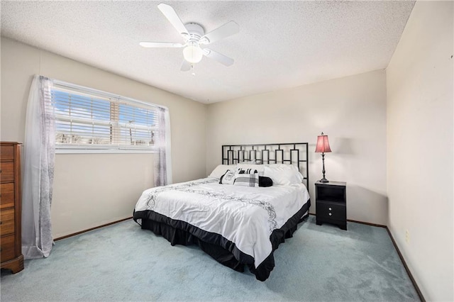 carpeted bedroom featuring ceiling fan, a textured ceiling, and baseboards