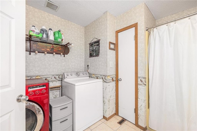 washroom with laundry area, washer / clothes dryer, a textured ceiling, and wallpapered walls