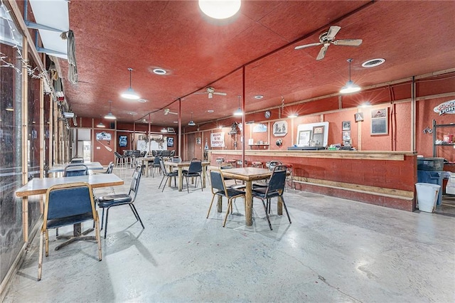 dining room featuring a ceiling fan, visible vents, and concrete flooring