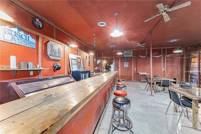 bar featuring concrete floors, visible vents, and a ceiling fan