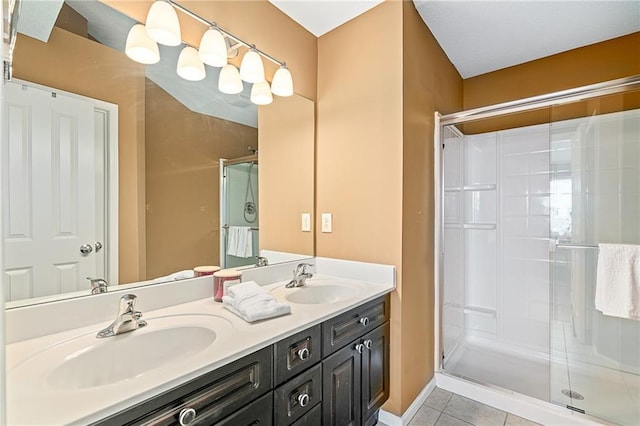 bathroom featuring double vanity, tile patterned flooring, a sink, and a shower stall