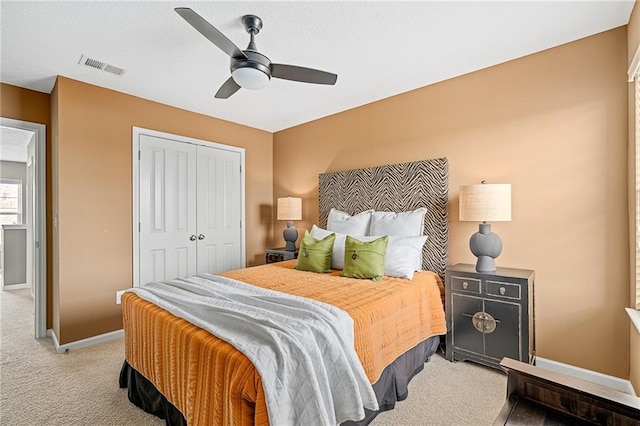 bedroom with a closet, visible vents, carpet flooring, ceiling fan, and baseboards