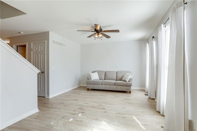 unfurnished room featuring a ceiling fan, light wood-type flooring, visible vents, and baseboards