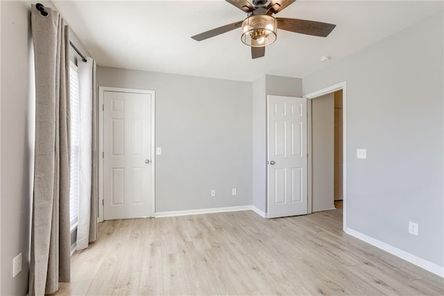 unfurnished bedroom featuring light wood-type flooring, ceiling fan, and baseboards