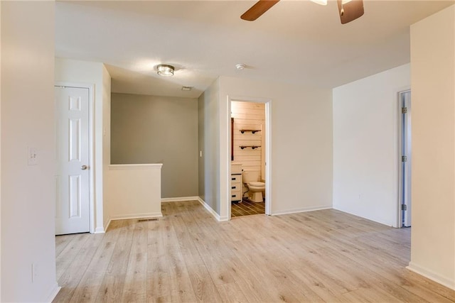 empty room featuring light wood-style floors, baseboards, and a ceiling fan