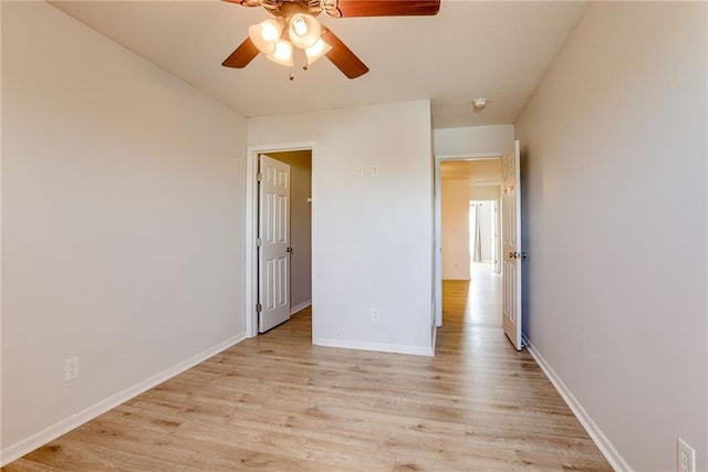 unfurnished bedroom with light wood-type flooring, ceiling fan, and baseboards