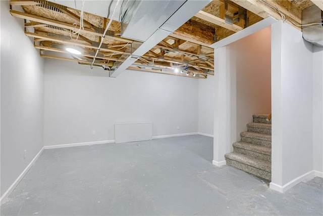 unfinished basement with stairway and baseboards