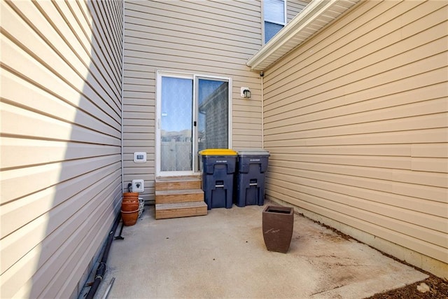 view of exterior entry with a patio