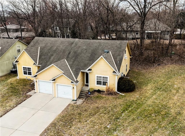 view of front of property featuring a front yard, roof with shingles, driveway, and an attached garage