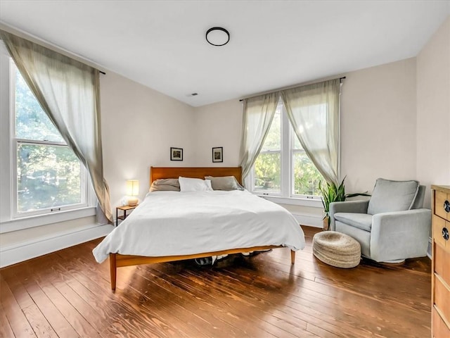 bedroom with hardwood / wood-style floors, multiple windows, and baseboards