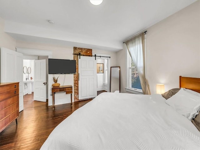 bedroom with dark wood finished floors and a barn door