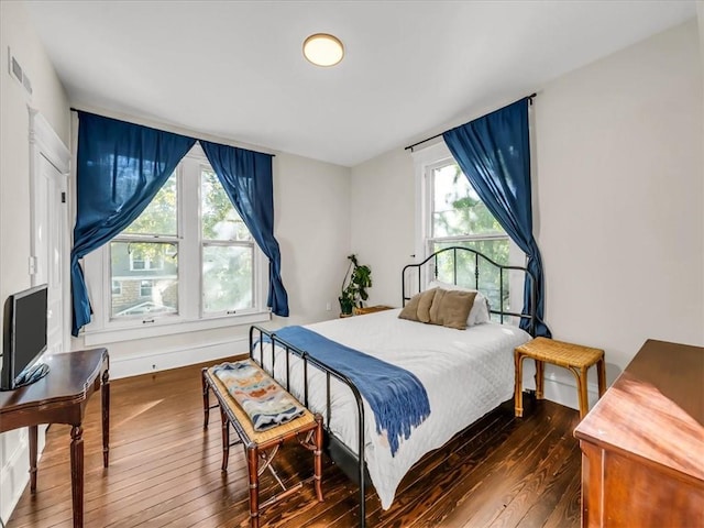 bedroom with hardwood / wood-style flooring, baseboards, and visible vents