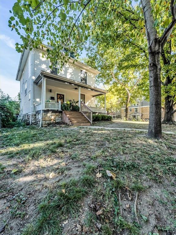 rear view of property featuring covered porch