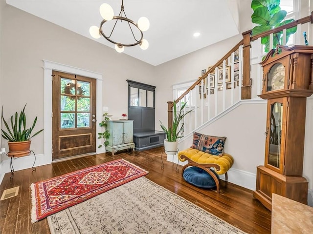 foyer entrance featuring stairs, plenty of natural light, wood-type flooring, and visible vents