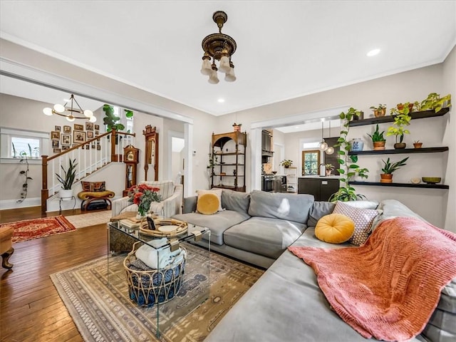 living room featuring a chandelier, hardwood / wood-style flooring, recessed lighting, baseboards, and stairs