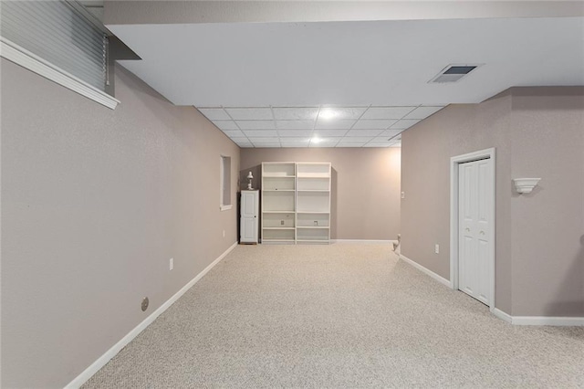 interior space with baseboards, visible vents, carpet, and a paneled ceiling