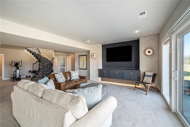 living area with light carpet, visible vents, stairs, and baseboards