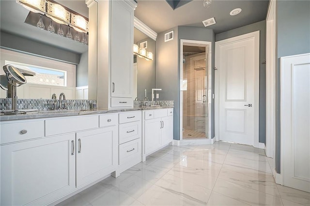 full bathroom with visible vents, marble finish floor, a sink, a shower stall, and double vanity