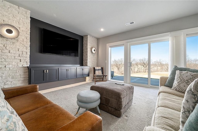 living area featuring visible vents and light carpet