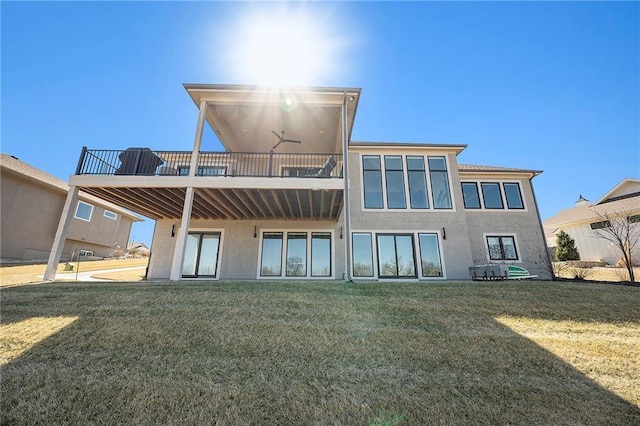 back of house with a yard, a balcony, and stucco siding