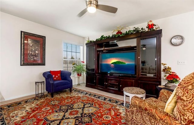 living area featuring a ceiling fan and baseboards