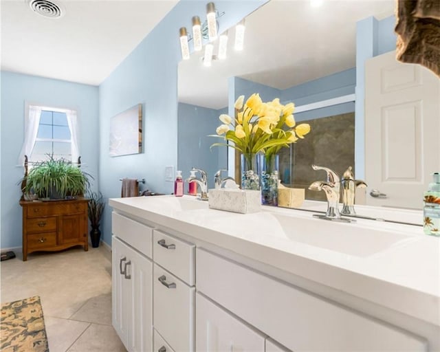 full bathroom featuring double vanity, a stall shower, visible vents, and a sink