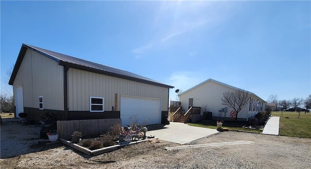 view of side of property with concrete driveway, an outbuilding, and a garage