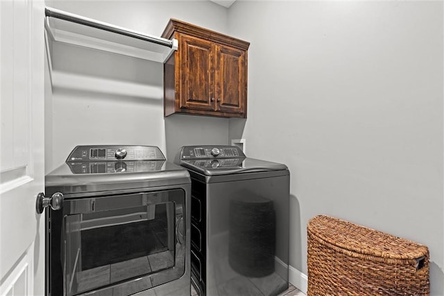 washroom with cabinet space and washing machine and clothes dryer