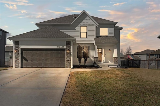 view of front of house with driveway, a shingled roof, an attached garage, fence, and a front lawn