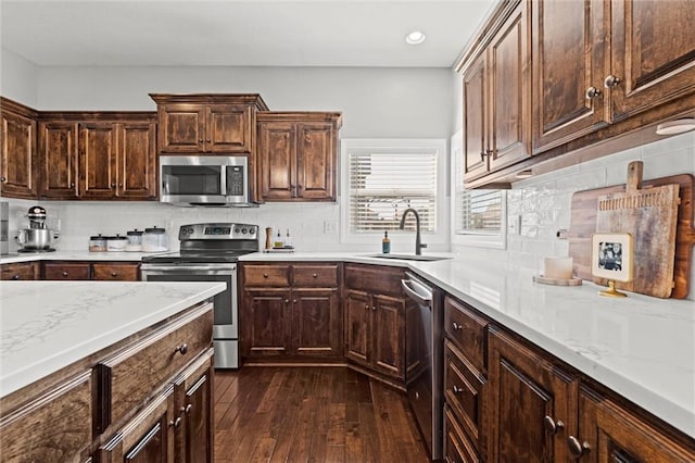 kitchen featuring decorative backsplash, dark wood-style flooring, appliances with stainless steel finishes, a sink, and recessed lighting
