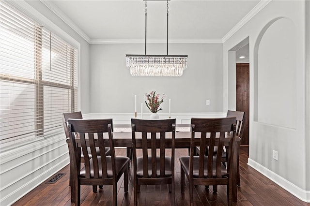 dining room featuring a notable chandelier, ornamental molding, and hardwood / wood-style floors