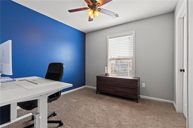 carpeted office space with baseboards, ceiling fan, and visible vents