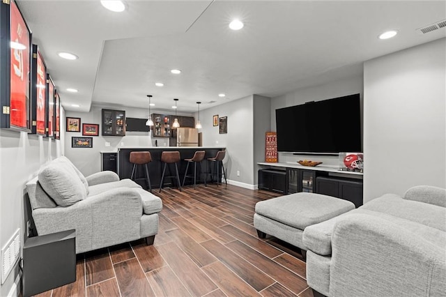 living area with indoor wet bar, recessed lighting, visible vents, and dark wood-style floors
