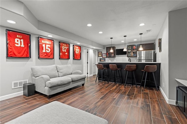 living area featuring baseboards, recessed lighting, wet bar, and visible vents