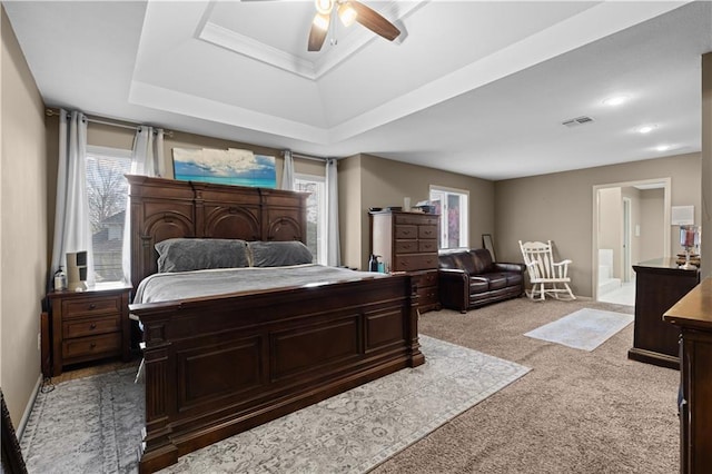 132 The Woodlands Dr, Gladstone, MO 64119 - bedroom with light carpet, visible vents, a ceiling fan, connected bathroom, and a raised ceiling