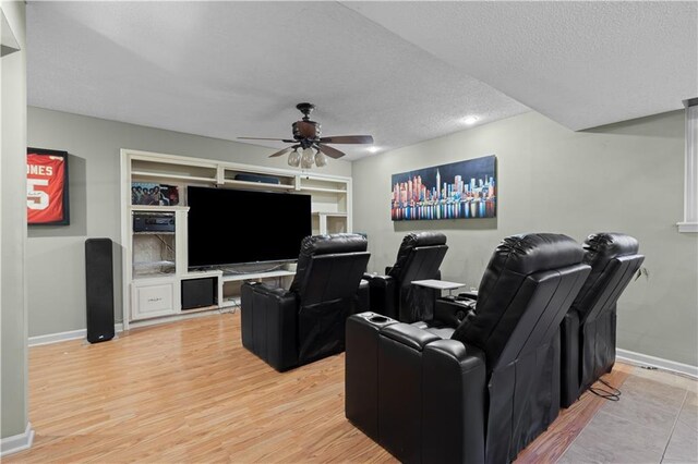 132 The Woodlands Dr, Gladstone, MO 64119 - home theater room featuring light wood-type flooring, baseboards, a textured ceiling, and ceiling fan