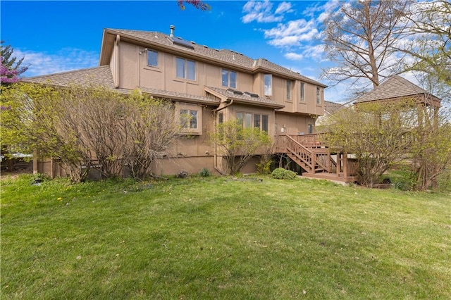 132 The Woodlands Dr, Gladstone, MO 64119 - back of property with a yard, stairway, stucco siding, and a deck