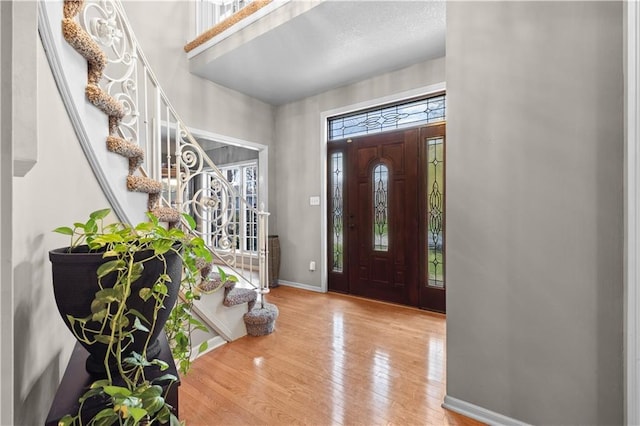 132 The Woodlands Dr, Gladstone, MO 64119 - entrance foyer featuring baseboards, wood finished floors, and stairs